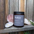 Selkie tea labeled 'Resilience' on a wooden surface with seashells and plants.